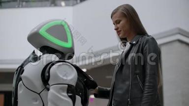 与机器人接触的快乐女人。 点击机器人屏幕.. 机器人和女人互动。